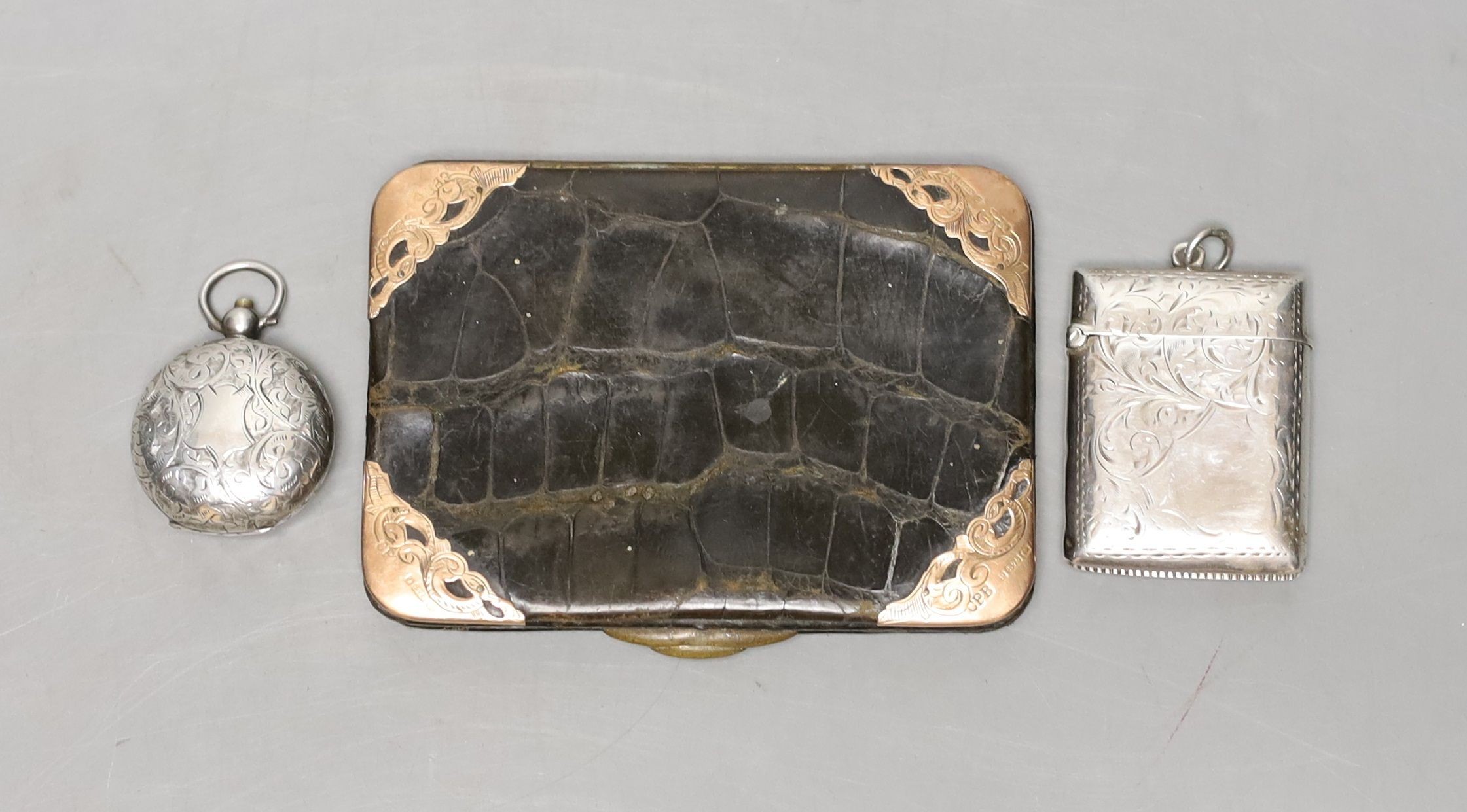 A late Victorian engraved silver sovereign case, a silver vesta case and an Edwardian 9ct gold mounted leather card purse.